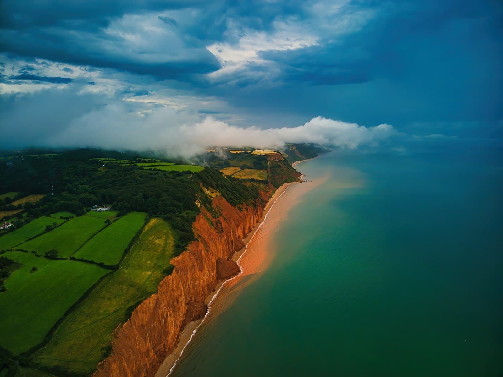 Aerial view of a dramatic coastline under storm clouds